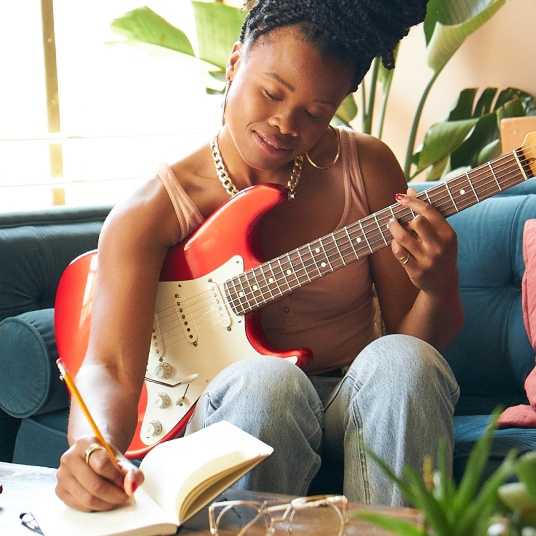 Person wearing Oura ring holding guitar