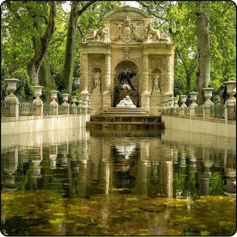 Image Description: A large, ornate monument adorned with statues sits at the foot of a long pond surrounded by trees.