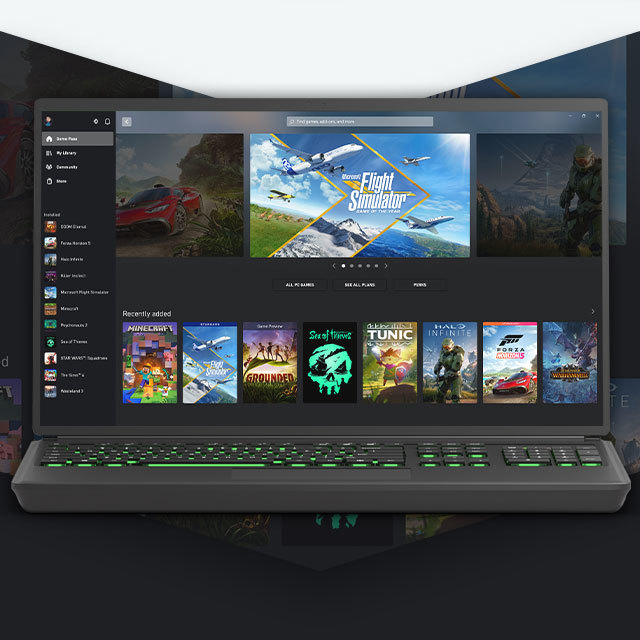 A laptop running the Xbox app with notable Xbox games displayed.