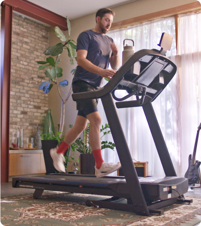 Man running on Horizon treadmill in home setting