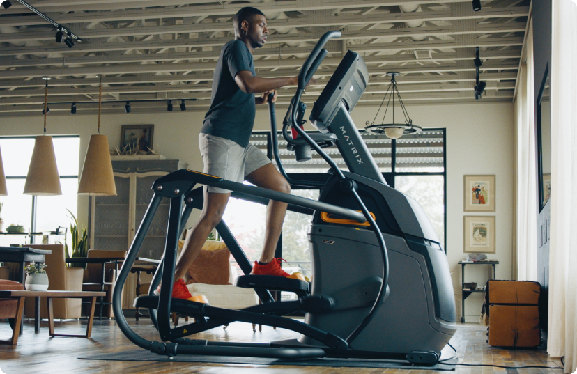 Man working out on Matrix Ascent Trainer in industrial home Man working out on Matrix Ascent Trainer in industrial home