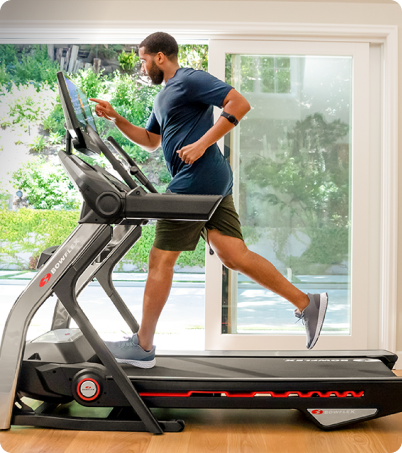 Man running on BowFlex Treadmill 22 in home office