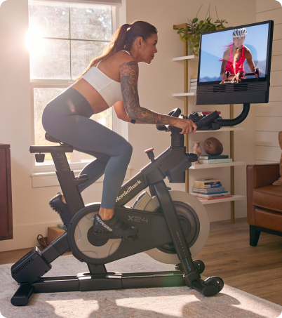 Woman riding NordicTrack cycle in home Woman riding NordicTrack cycle in home