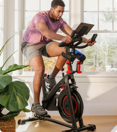 Man riding BowFlex C6 Bike in sunny home office Man riding BowFlex C6 Bike in sunny home office