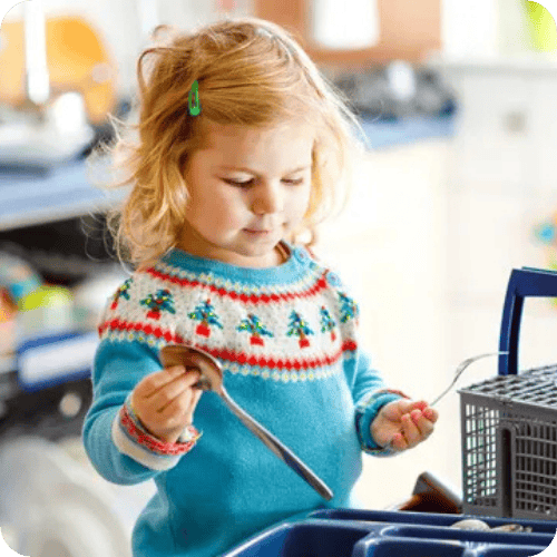 a little girl helping to sort cutlery from the dishwasher
