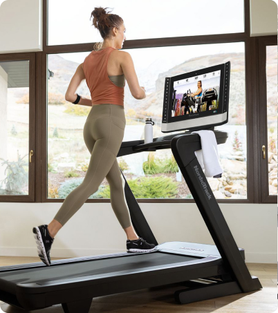 Woman running on NordicTrack treadmill in home.