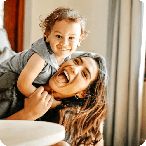A smiling mom playing with her little boy