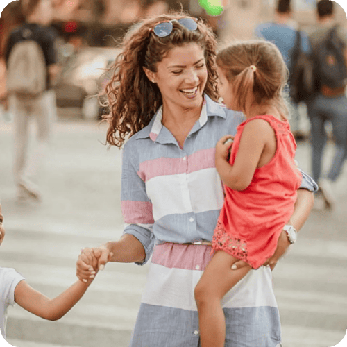 A smiling mom walking with her two little girls