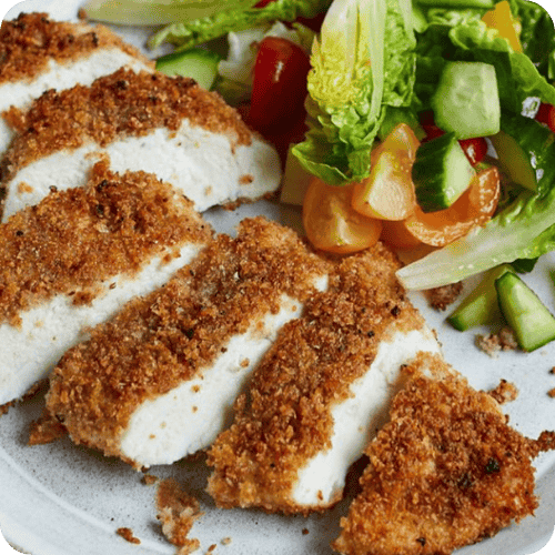 A sliced breaded chicken breast with salad on the side is one of the best chicken breast recipes