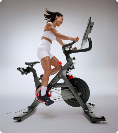 Woman in white riding Peloton Cross Training Bike+