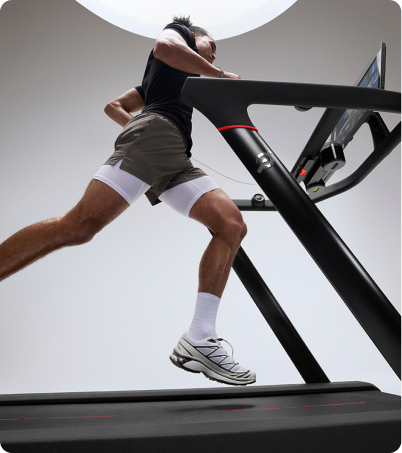 Man running on Peloton Tread in bright studio Man running on Peloton Tread in bright studio