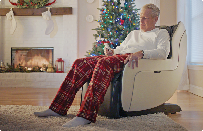 Man in pajamas relaxing in CirC massage chair in front of Christmas Tree