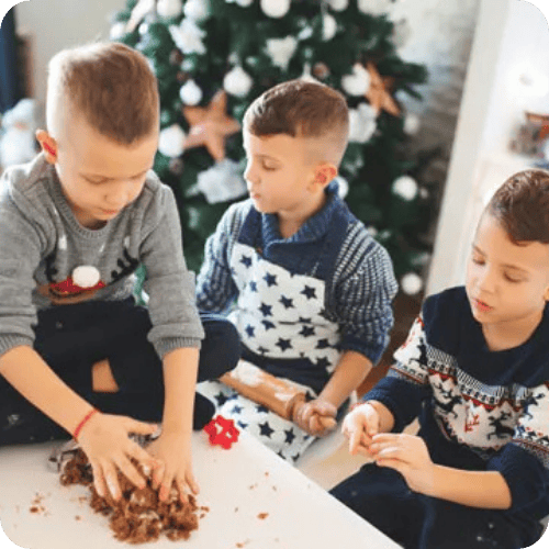 three brothers doing holiday baking with a christmas tree in the background
