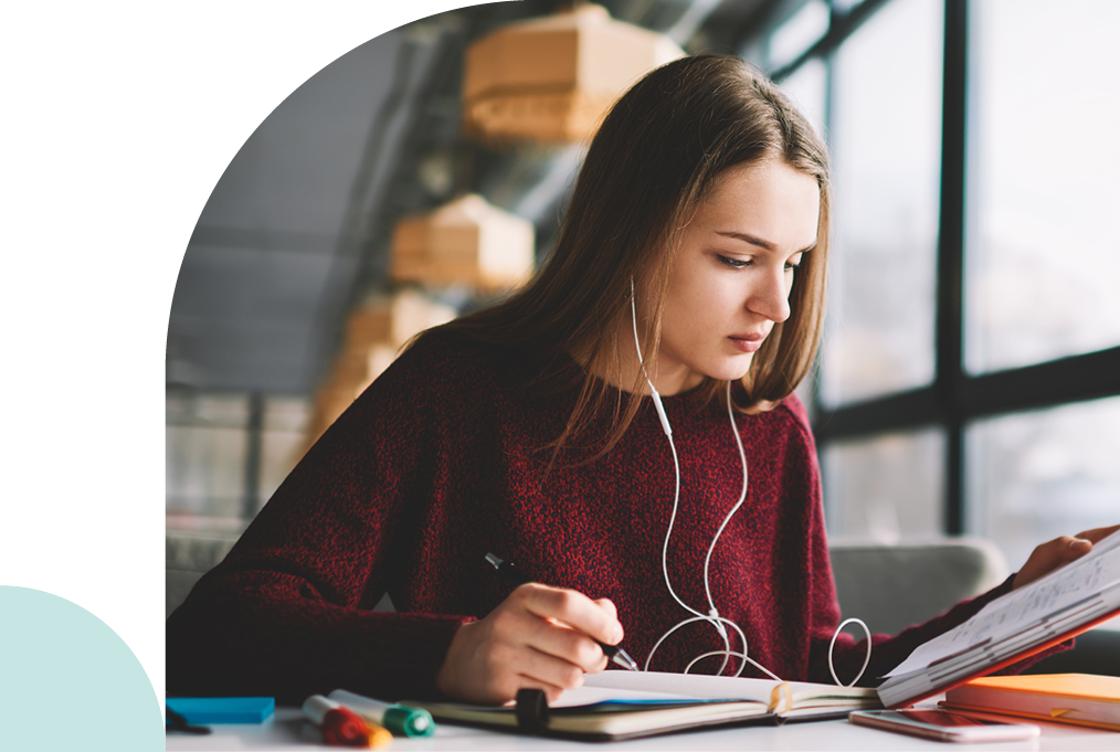 Woman reading her notebook with earbuds in