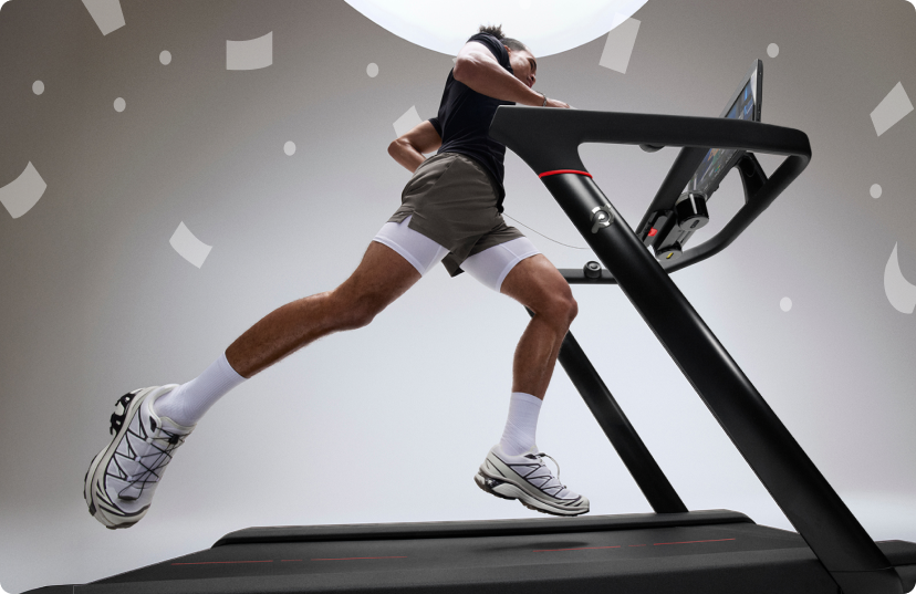 Man running on Peloton Tread in bright gray studio