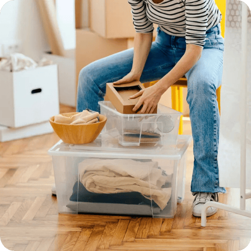 a woman organizing boxes and bins in a house