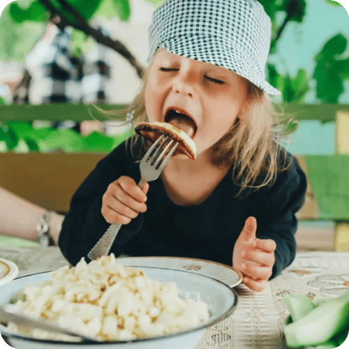 a kid eating veggies thanks to a nutritionist's tip