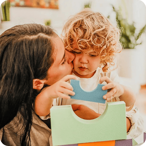 a mom playing blocks with her toddler and not worrying about developmental milestones