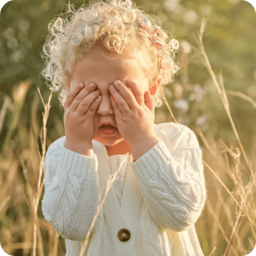 a little girl covering her eyes