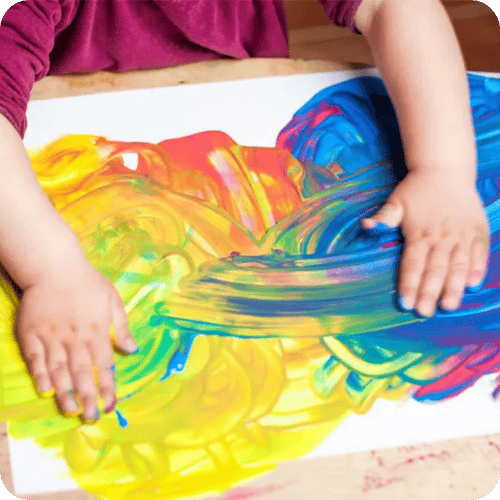 a kid making finger paint art for a story on what to do with your kid's artwork