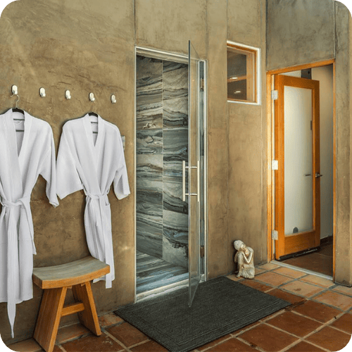 a romantic airbnb with a spa and robes handing on hooks