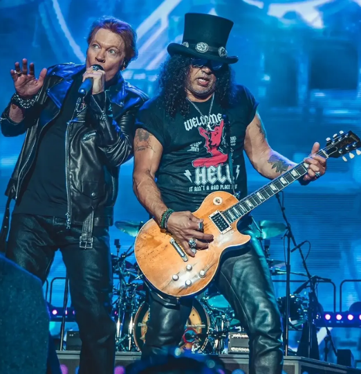 Slash and Axl Rose perform on stage.