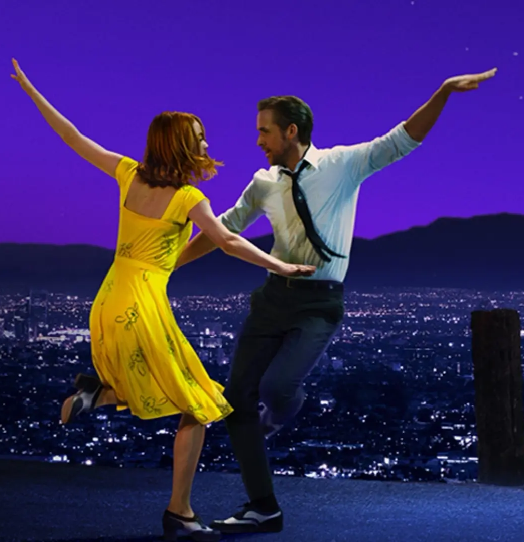Dance scene from La La Land featuring a couple performing against a city skyline at dusk with a vibrant purple sky.