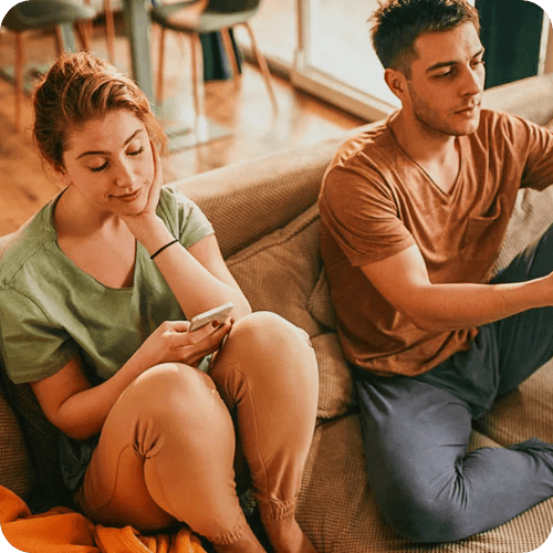 a couple sitting on the couch with unresolved resentment between them