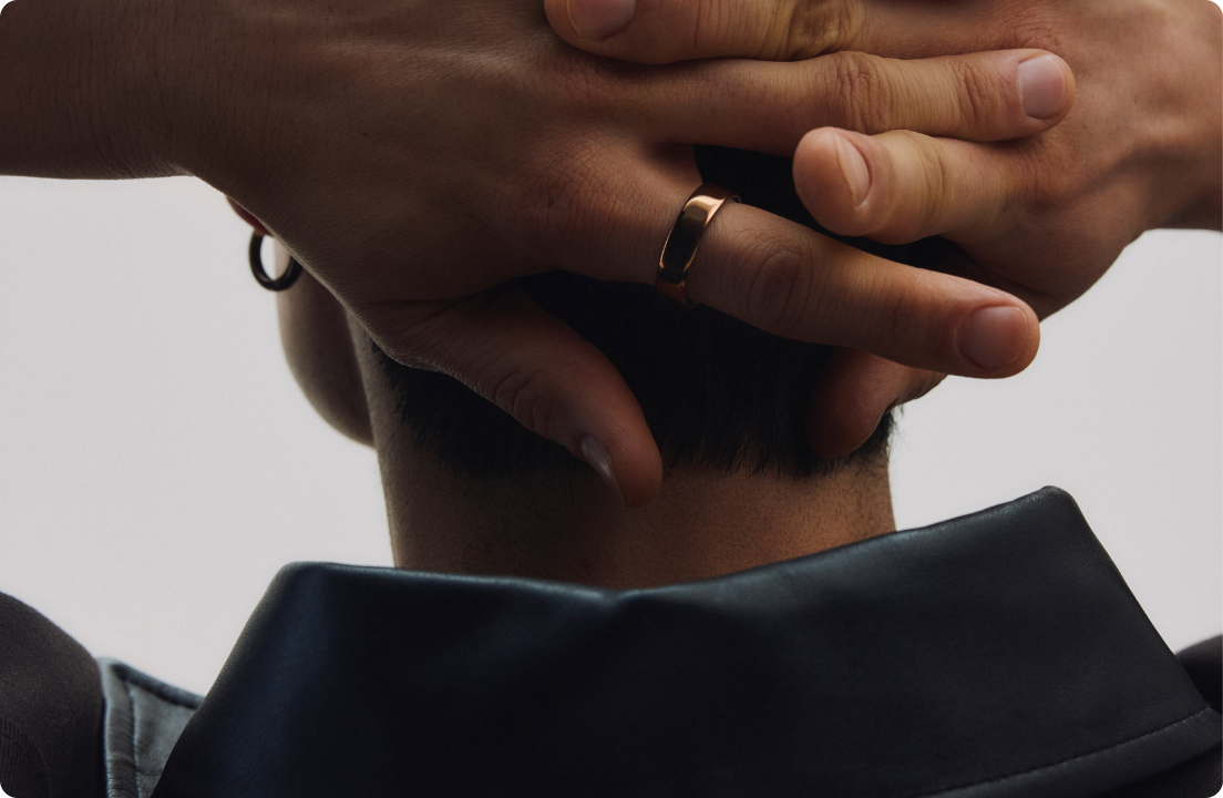Person wearing Oura ring with hands behind their head