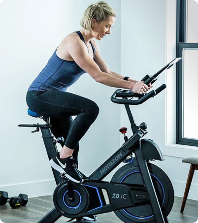 Athletic woman in blue top riding Horizon 7.0 IC Bike