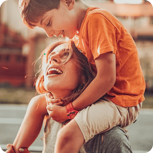 a mom with her son on her shoulders and glowing skin