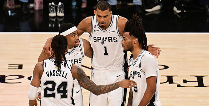 The Spurs huddle on the court.
