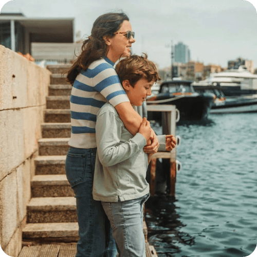 a mom at the pier hugging her son