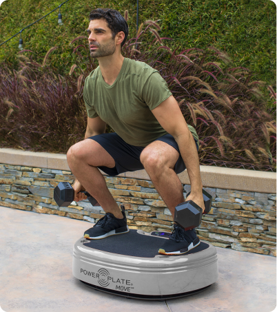 Man working out on Power Plate MOVE while holding dumbbells outdoors