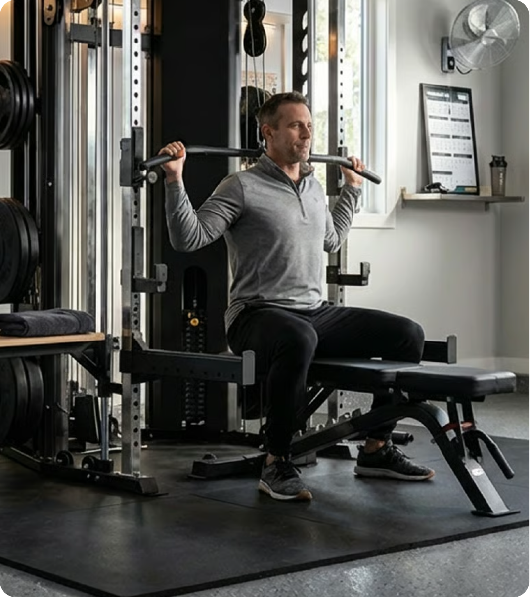 Man performing strength training with Force USA equipment in a home gym.