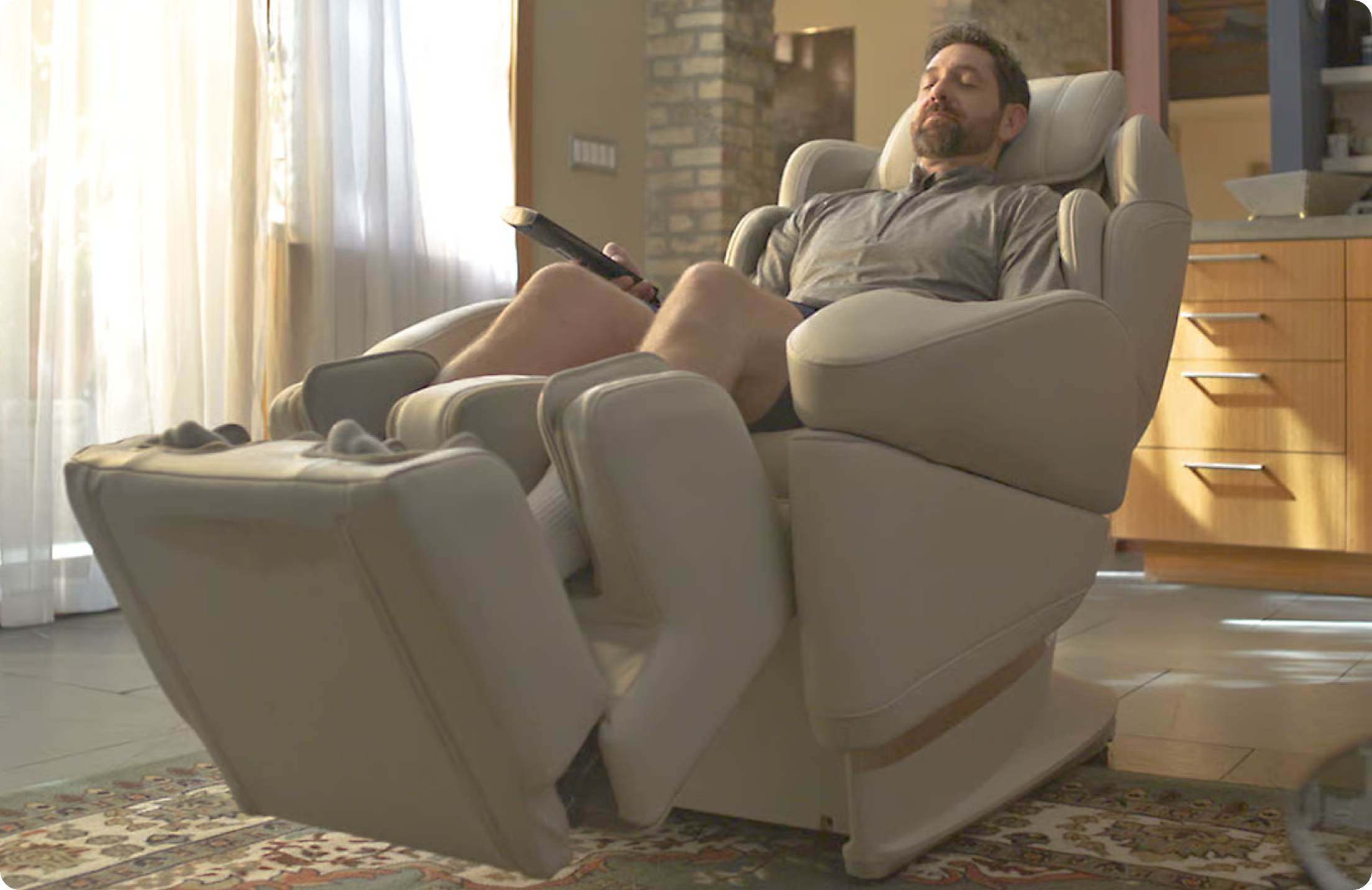 Man relaxing in a premium massage chair at home. 