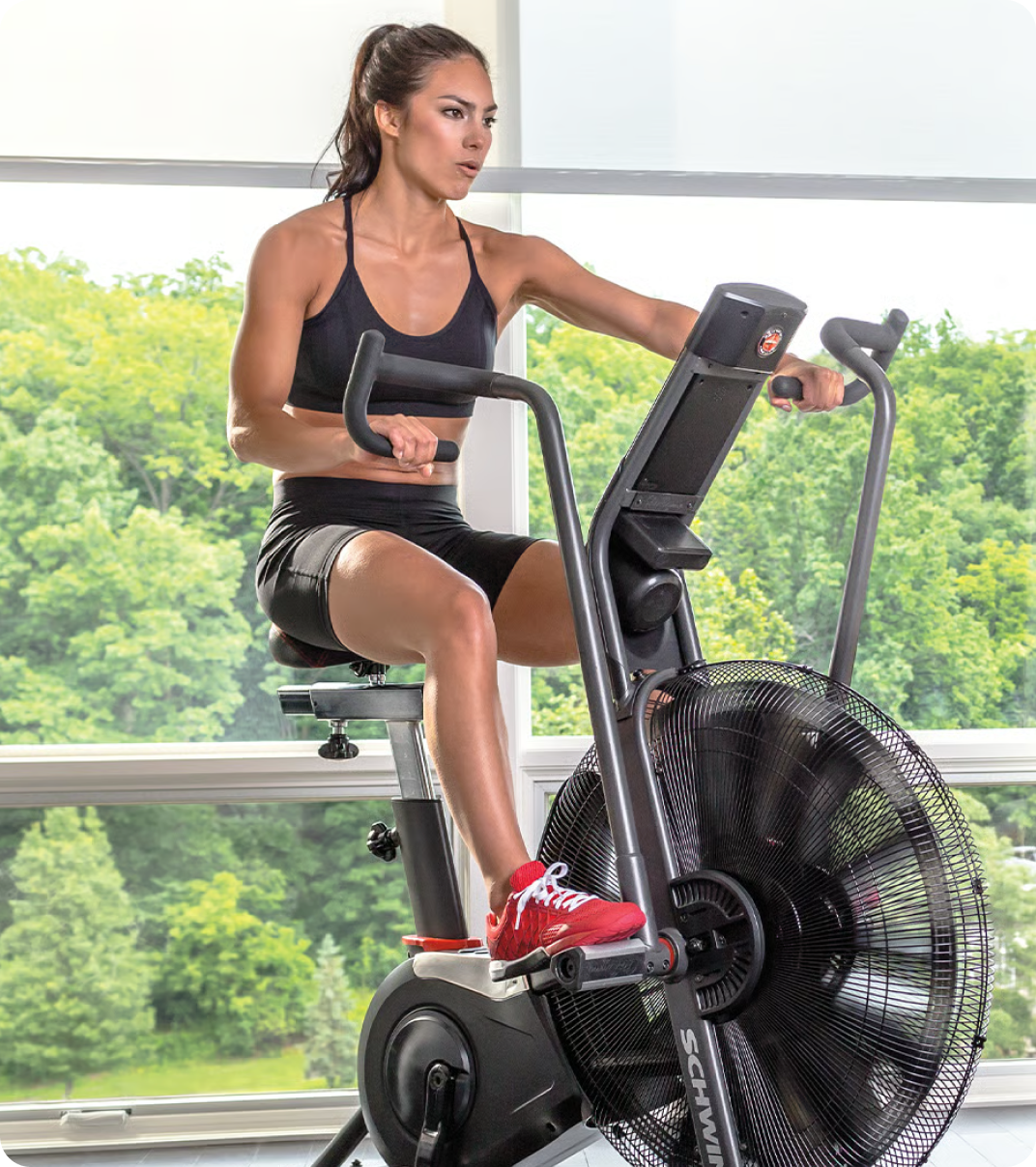 Woman training at home on a Schwinn bike.