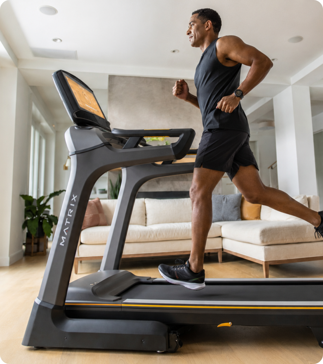 Man running on a Matrix treadmill at home.