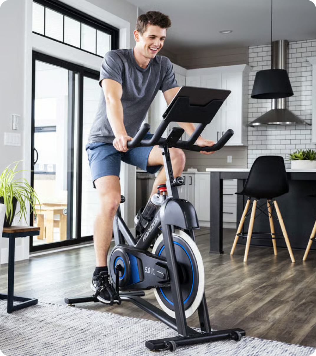 Man riding a Bowflex indoor bike at home.