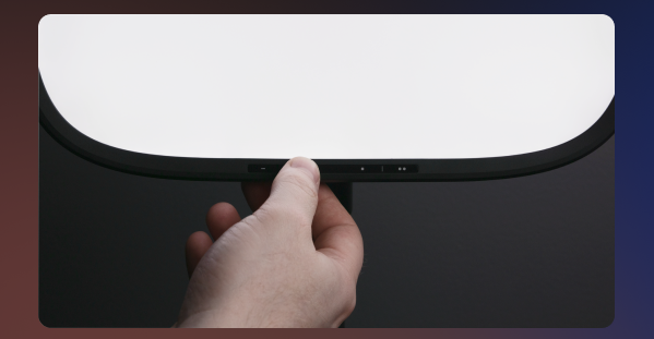 Hand adjusting the onboard touch controls on the bottom edge of Key Light Air MK.2
