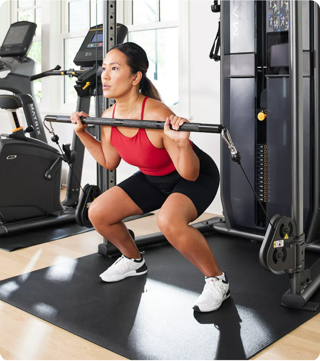 Woman using a Matrix Functional Trainer for strength training.