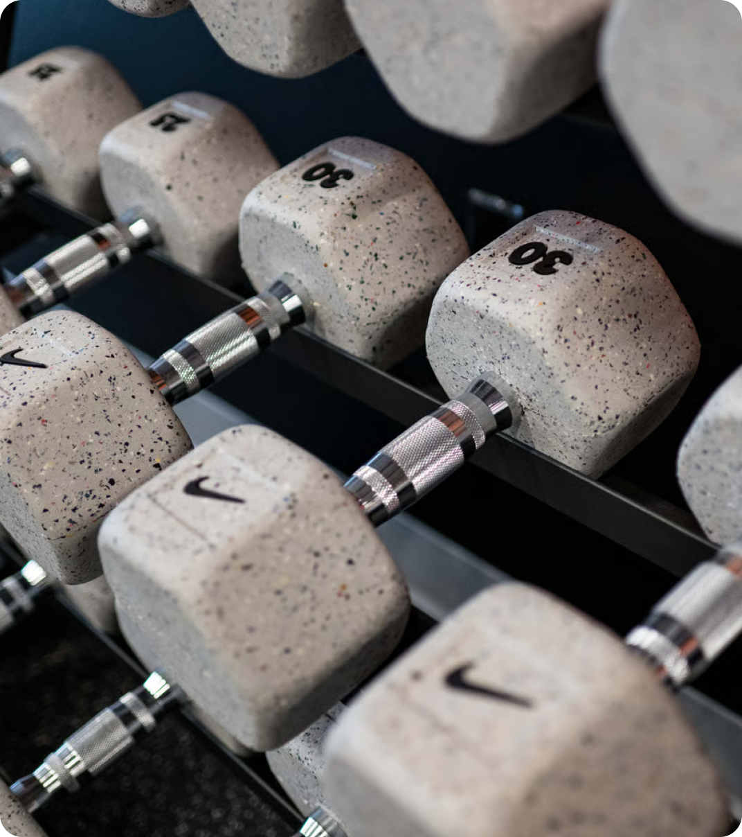 Nike dumbbells arranged on a weight rack.