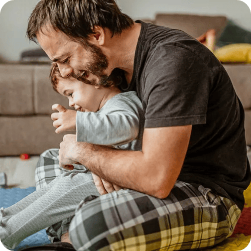 a dad helping his toddler wind down with calming exercises like rocking back and forth