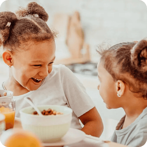 sisters eating a yummy toddler breakfast together