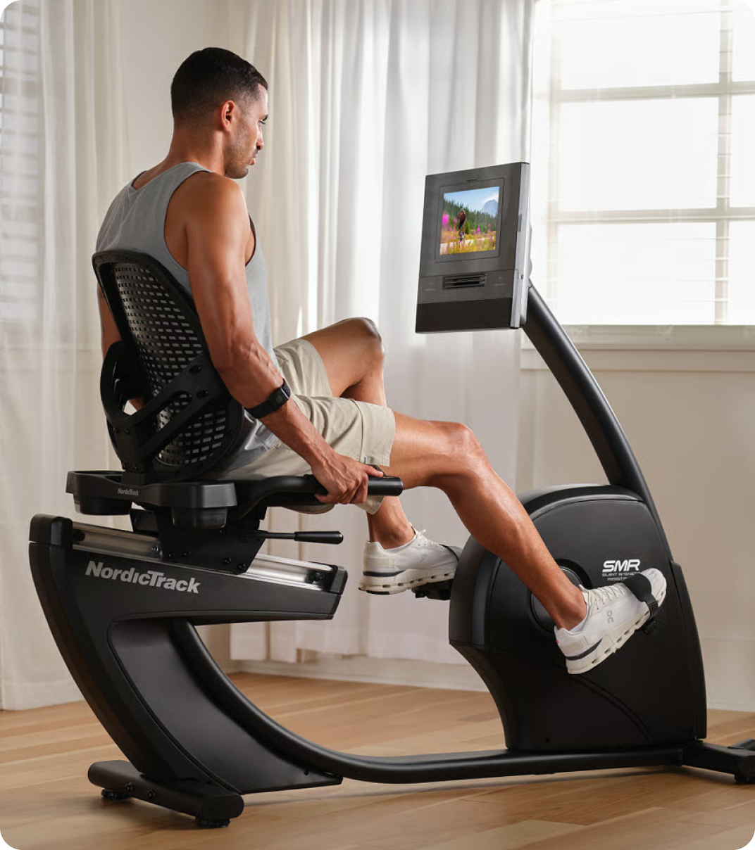 Man riding a NordicTrack recumbent bike at home. Man riding a NordicTrack recumbent bike at home.