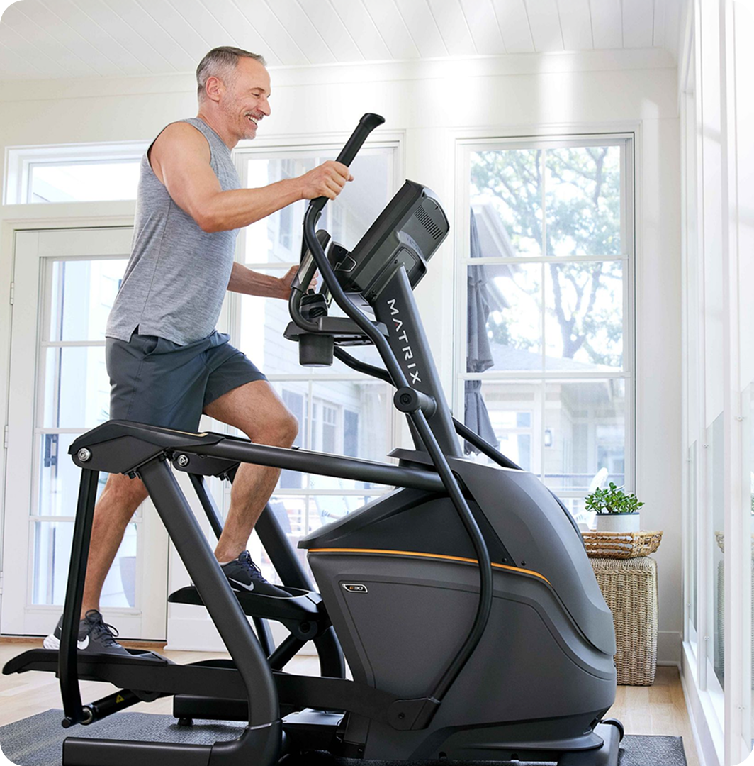 Man working out on a Matrix elliptical at home