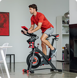 Man riding a Schwinn indoor cycling bike at home
