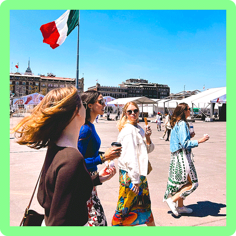 Image Description: Women holding coffee and snacks walking in Mexico City